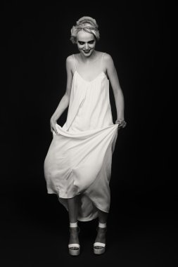 Karanlık bir arka plan üzerinde vintage elbiseli güzel sarışın