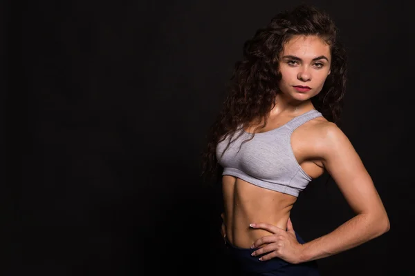 A bela menina de esportes em um fundo escuro — Fotografia de Stock