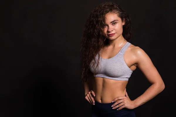 A bela menina de esportes em um fundo escuro — Fotografia de Stock