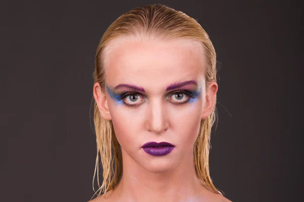Hermosa modelo con maquillaje de arte sobre un fondo oscuro — Foto de Stock
