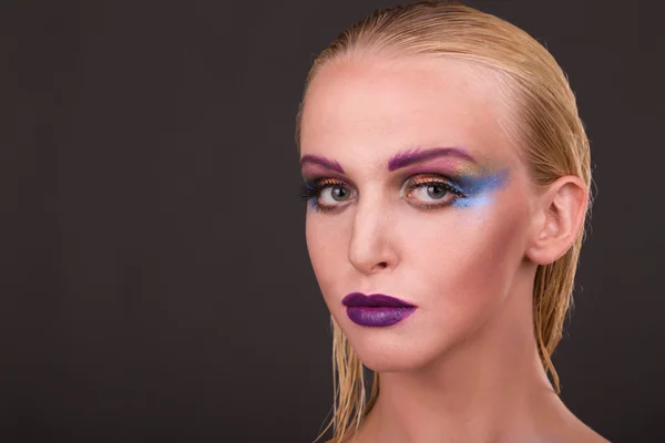 Hermosa modelo con maquillaje de arte sobre un fondo oscuro — Foto de Stock