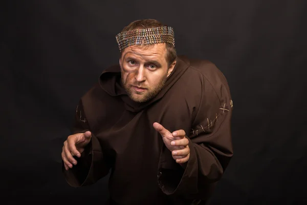 O ator sob o disfarce de um mendigo em um fundo escuro — Fotografia de Stock