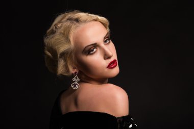 Karanlık bir arka plan üzerinde vintage elbiseli güzel sarışın