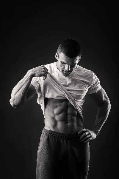 Muskulös man i en sport jacka på en mörk bakgrund — Stockfoto