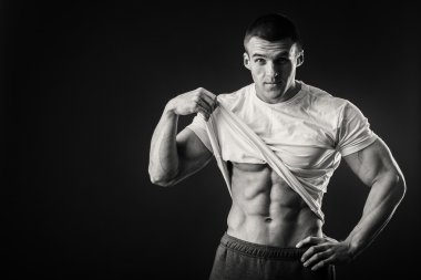 Karanlık bir arka plan üzerinde bir spor ceketli kaslı adamı