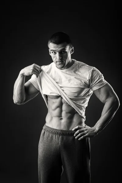 Muscular man in a sports jacket on a dark background — Stock Photo, Image