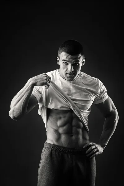在运动茄克衫在一个黑暗的背景中的肌肉男 — 图库照片