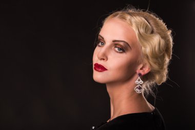 Karanlık bir arka plan üzerinde vintage elbiseli güzel sarışın