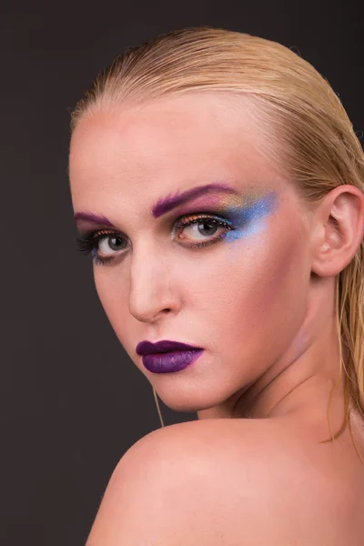 Hermosa modelo con maquillaje de arte sobre un fondo oscuro — Foto de Stock