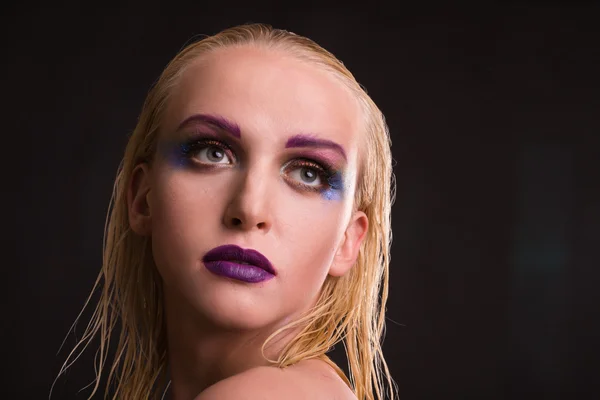 Hermosa modelo con maquillaje de arte sobre un fondo oscuro — Foto de Stock
