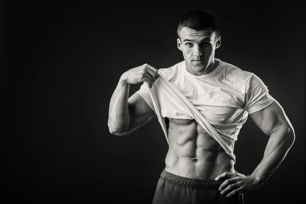 Uomo muscoloso in giacca sportiva su sfondo scuro — Foto Stock