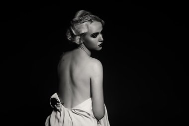 Karanlık bir arka plan üzerinde vintage elbiseli güzel sarışın