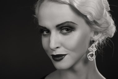 Karanlık bir arka plan üzerinde vintage elbiseli güzel sarışın