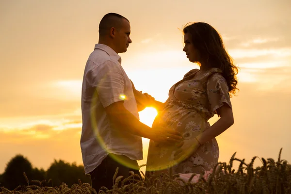 Mulher grávida bonita em um passeio em um campo de trigo — Fotografia de Stock