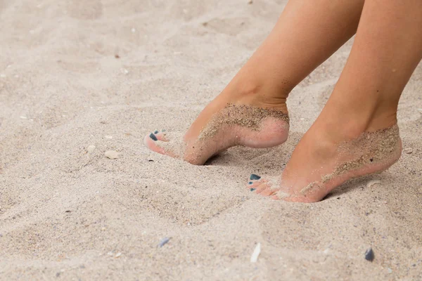 Belle gambe femminili con pedicure brillante sulla spiaggia — Foto Stock