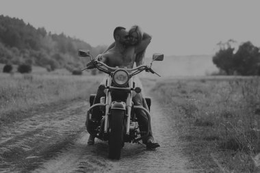 Kaslı adam bir motosiklet orta alan yolun üzerinde güzel bir kadınla