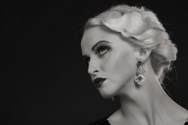 Karanlık bir arka plan üzerinde vintage elbiseli güzel sarışın