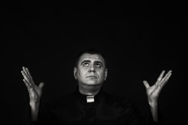 Karanlık bir arka plan karşı bir rahip kılığında bir profesyonel tiyatro oyuncusu