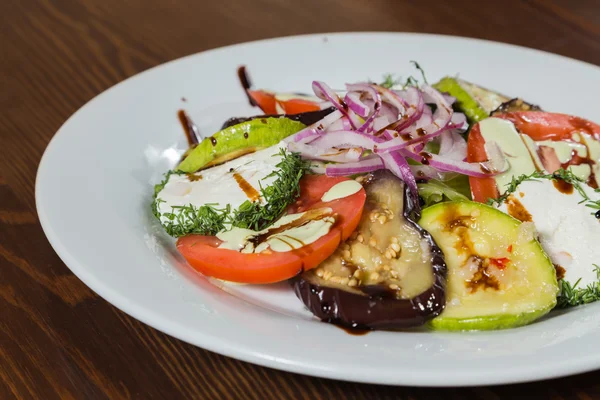 Tasty grilled vegetables on white plate with sauce