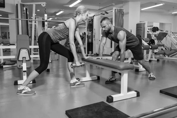 Jeune couple dans la salle de gym à l'entraînement conjoint — Photo