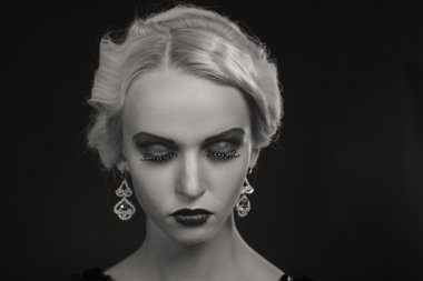 Karanlık bir arka plan üzerinde vintage elbiseli güzel sarışın