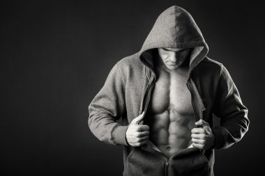 Karanlık bir arka plan üzerinde bir spor ceketli kaslı adamı