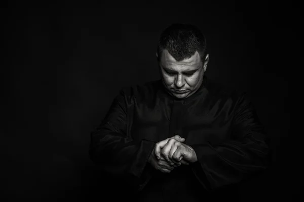 Професійний сценічний актор у вимові священика на темному тлі — стокове фото