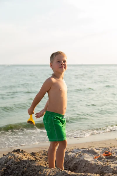 Sahilde kumda oynayan genç bir çocuk