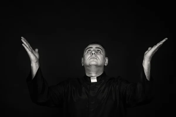 Ένα επαγγελματικό στάδιο ηθοποιός με το πρόσχημα ενός ιερέα με ένα μαύρο φόντο — Φωτογραφία Αρχείου