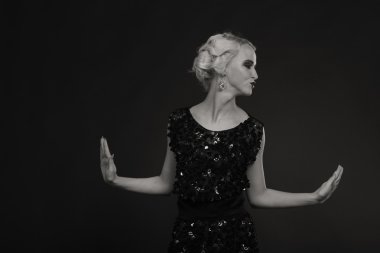 Karanlık bir arka plan üzerinde vintage elbiseli güzel sarışın