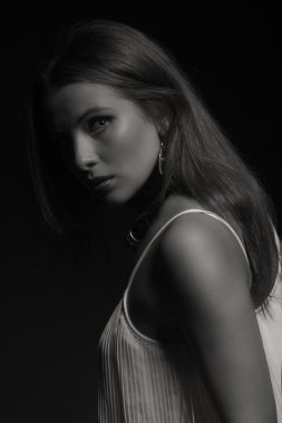 Karanlık bir arka plan üzerinde beyaz elbiseli güzel esmer