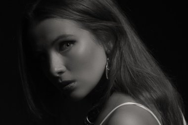 Karanlık bir arka plan üzerinde beyaz elbiseli güzel esmer