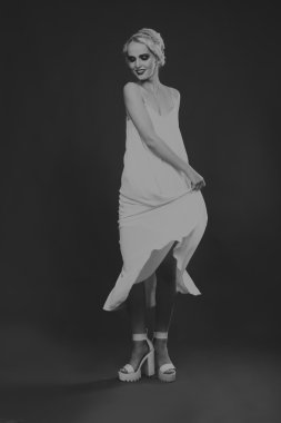 Karanlık bir arka plan üzerinde vintage elbiseli güzel sarışın