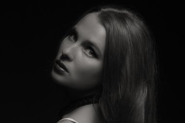 Karanlık bir arka plan üzerinde beyaz elbiseli güzel esmer