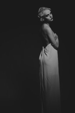 Karanlık bir arka plan üzerinde vintage elbiseli güzel sarışın