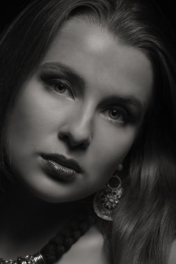 Karanlık bir arka plan üzerinde beyaz elbiseli güzel esmer