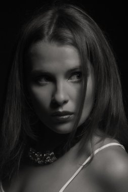 Karanlık bir arka plan üzerinde beyaz elbiseli güzel esmer