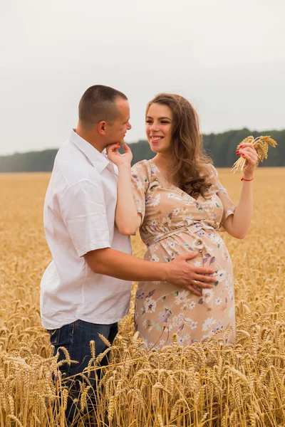 Casal jovem entre o campo de trigo — Fotografia de Stock