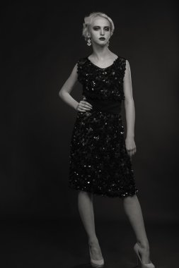 Karanlık bir arka plan üzerinde vintage elbiseli güzel sarışın