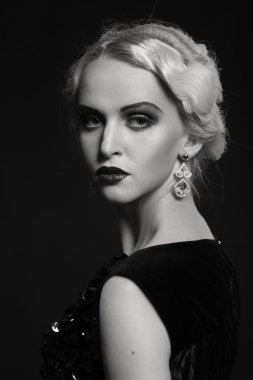 Karanlık bir arka plan üzerinde vintage elbiseli güzel sarışın