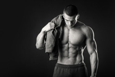 Karanlık bir arka plan üzerinde bir spor ceketli kaslı adamı