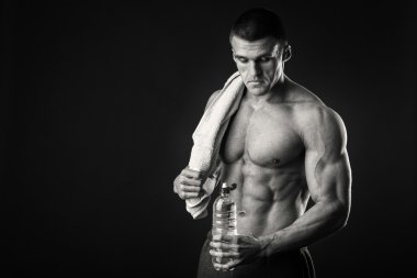 Kaslı adam ellerini karanlık bir arka plan üzerine bir havlu ile