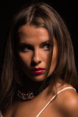 Karanlık bir arka plan üzerinde beyaz elbiseli güzel esmer