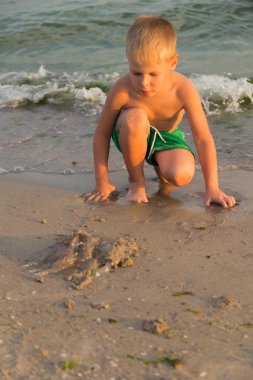 Sahilde kumda oynayan genç bir çocuk