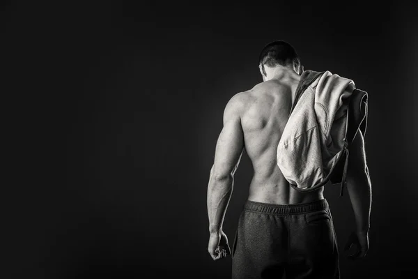 Hombre musculoso en una chaqueta deportiva sobre un fondo oscuro — Foto de Stock