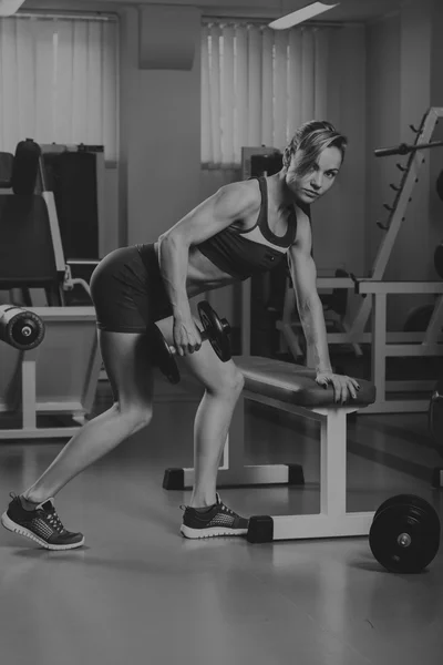 Hermosa chica toma ejercicios en el gimnasio — Foto de Stock