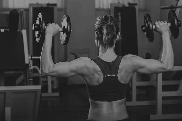 Hermosa chica toma ejercicios en el gimnasio — Foto de Stock