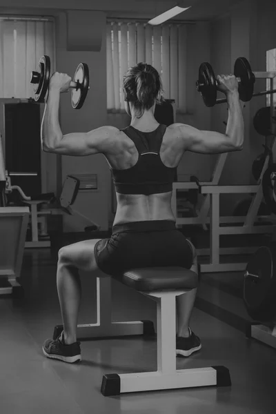 Menina bonita faz exercícios no ginásio — Fotografia de Stock