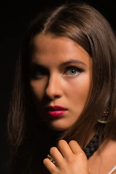 Karanlık bir arka plan üzerinde beyaz elbiseli güzel esmer