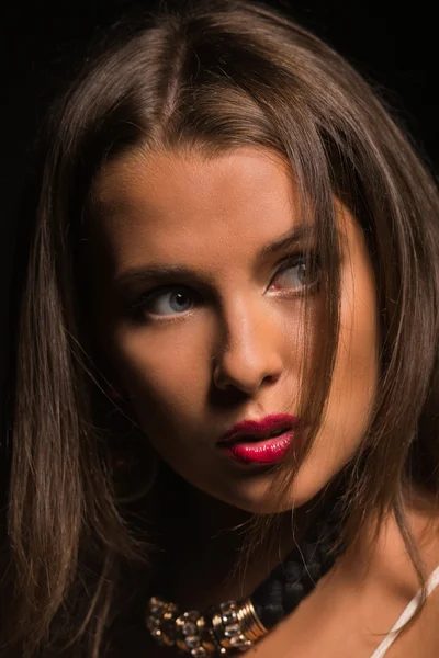 Karanlık bir arka plan üzerinde beyaz elbiseli güzel esmer